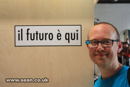 Sean wearing Google Glass, with an Italian sign that reads: "il futuro e qui"